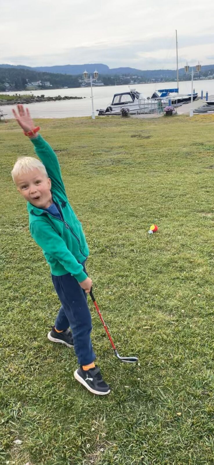 Tobbe med golfkølle og hevet arm, helt i sin egen spillglede